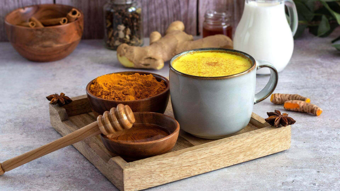 Collombatti Naturals turmeric chai in a cup with turmeric powder on the side