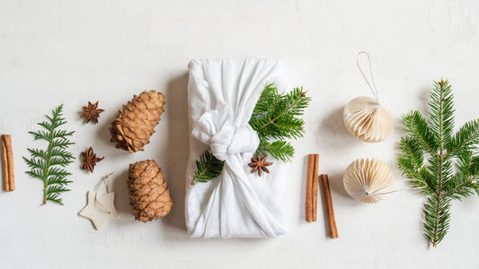 Collombatti Naturals step by step guide to the best eco friendly gift boxes blog Brown paper wrapped gift with white cotton string and a small posy of white daisies under the string
