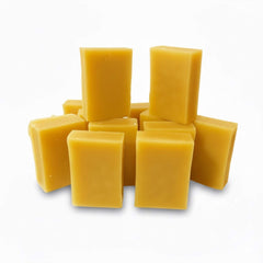 Yellow rectangular soap bars stacked on a white background