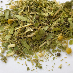 Organic Calm Herbal Tea, showing a blend of dried chamomile flowers, lemon verbena, linden flowers, and other natural botanicals. The loose-leaf tea is displayed against a white background, highlighting its fresh, earthy texture and calming herbal ingredients.