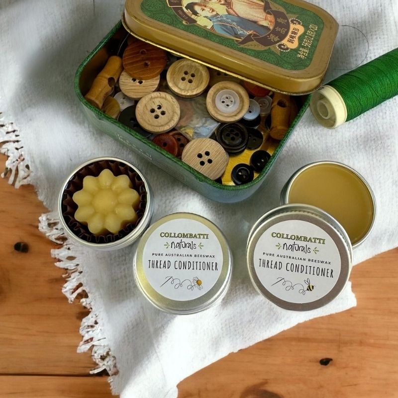 Beeswax thread waxes with  a tin full of button on a white cloth