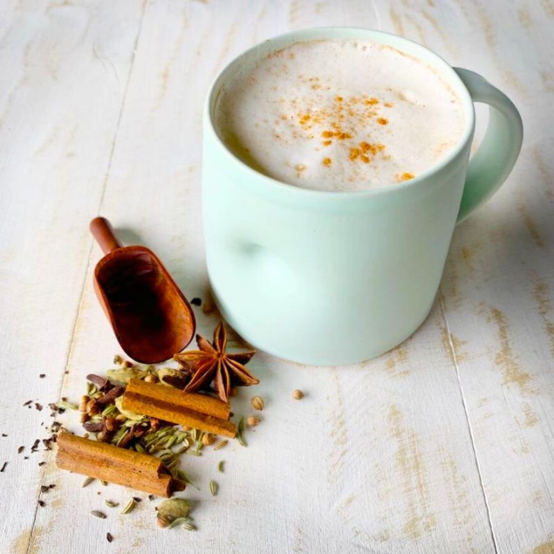 Collombatti Naturals Sticky Honey Chai in a light green cup with chai spices beside